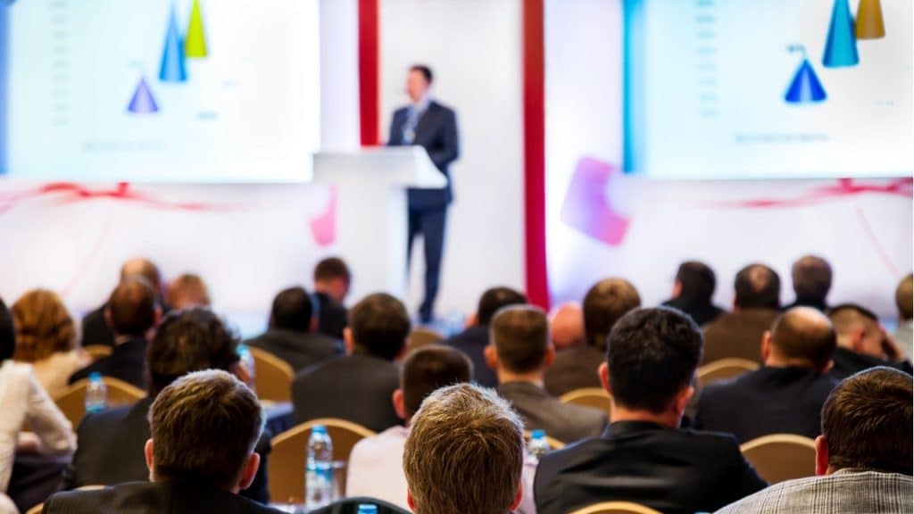 Image of a presenter on an event with audience